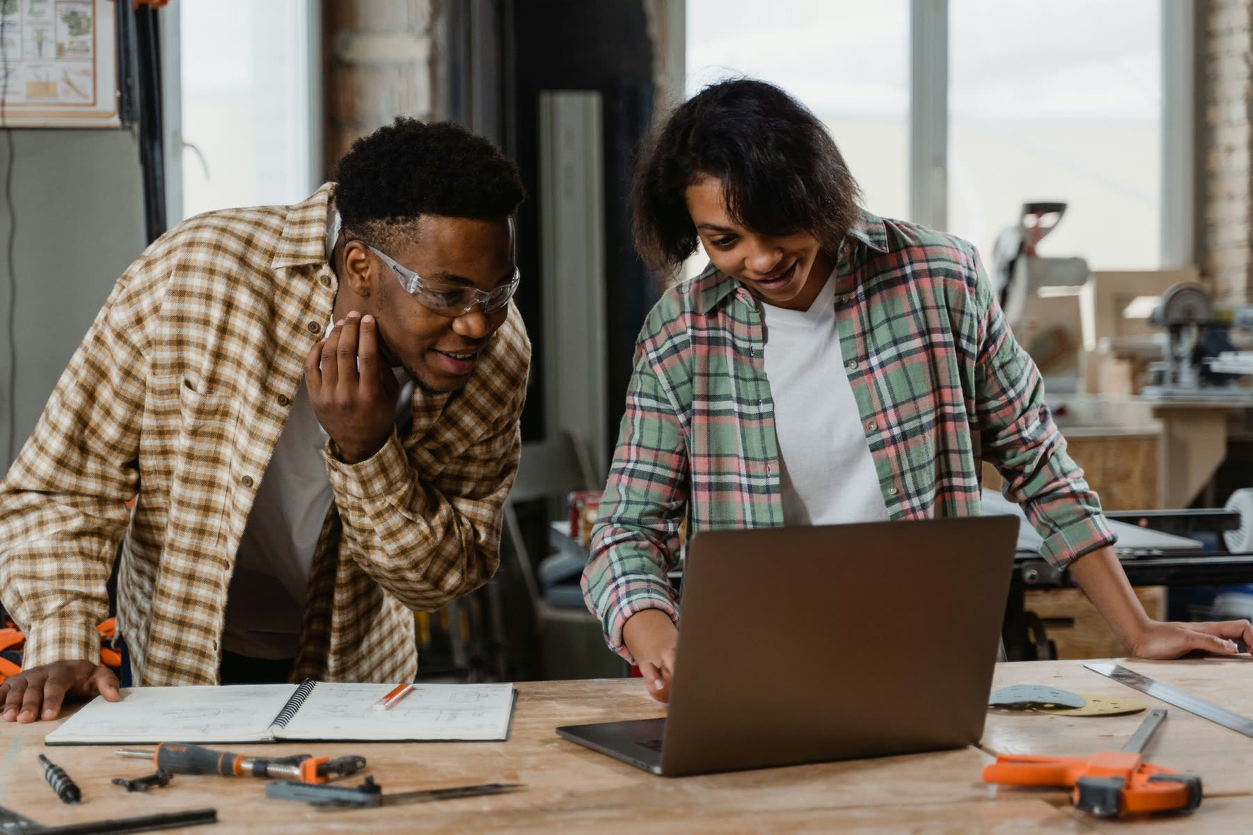 Two business owners working through a system on a laptop in their workshop