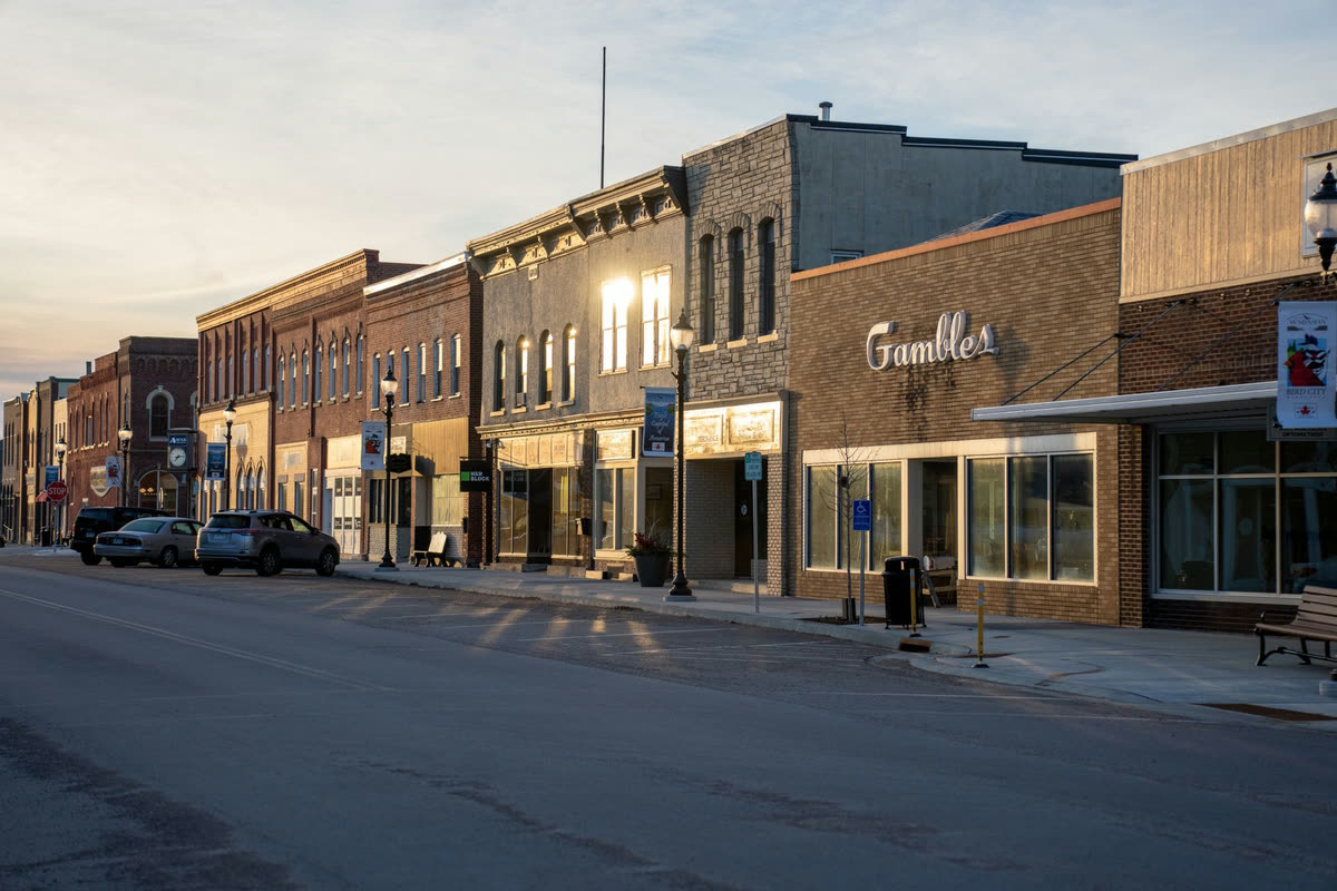 A small town main street of brick storefronts at golden hour